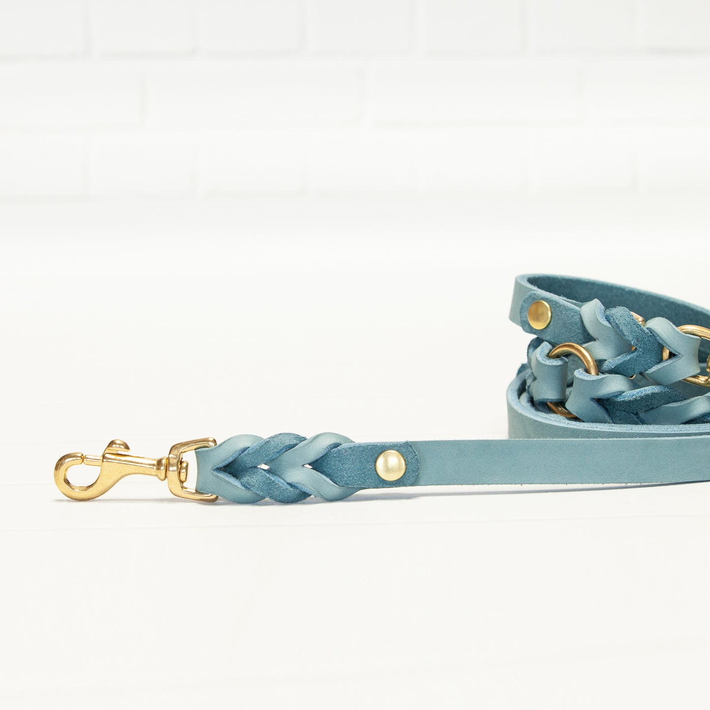 Nahaufnahme der geflochtenen MILA-Hundeleine in Eisblau – die goldenen Beschläge setzen elegante Akzente am geschmeidigen Leder.