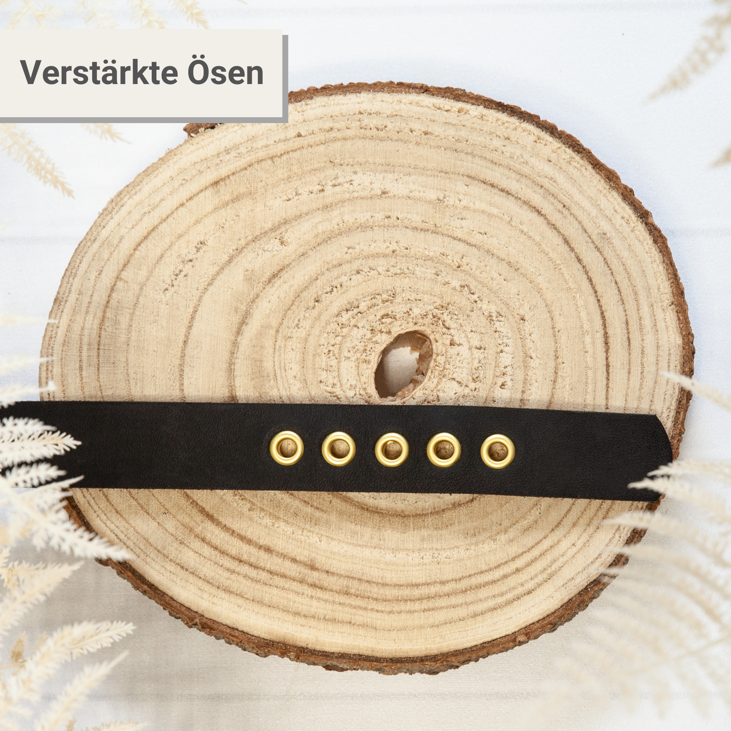 Halsband KIWI in Schwarz – verstärkte Ösen im Detail, handgefertigtes Lederhalsband auf Holzscheibe präsentiert