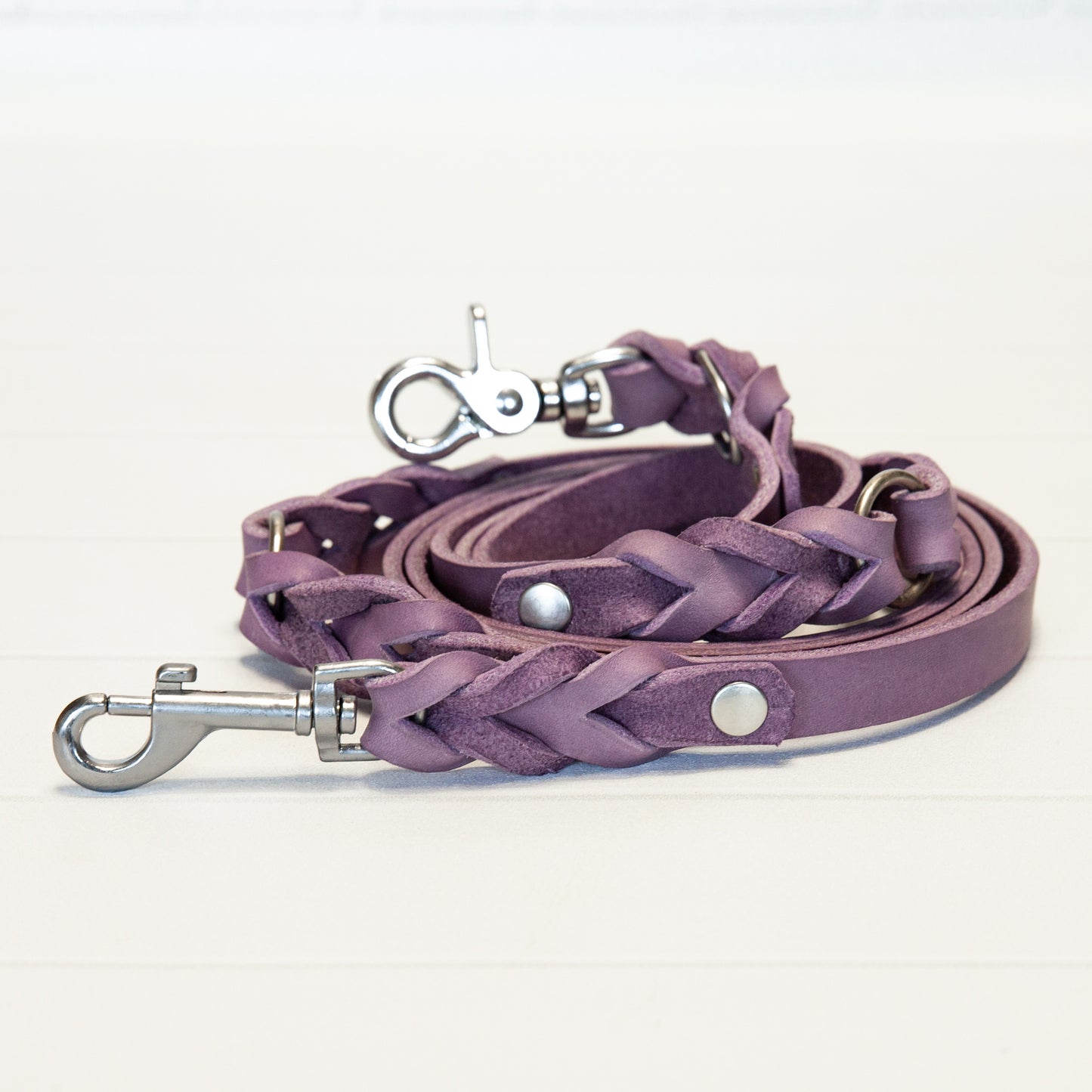 Handgeflochtene Hundeleine aus butterweichem Lavendel-Leder, elegant aufgerollt präsentiert – ein liebevoller Begleiter für stilvolle Gassirunden.