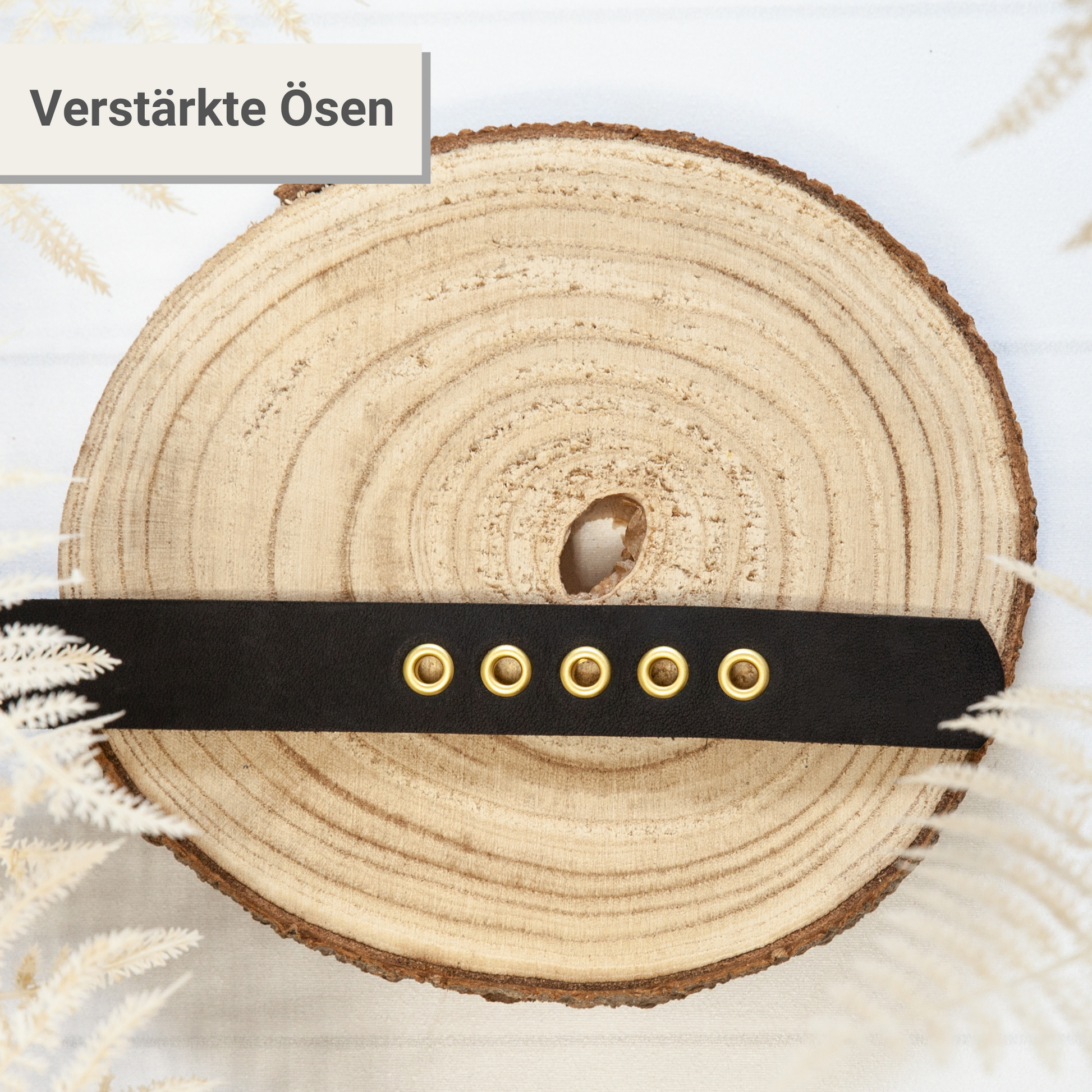 Halsband KIWI in Schwarz – verstärkte Ösen im Detail, handgefertigtes Lederhalsband auf Holzscheibe präsentiert